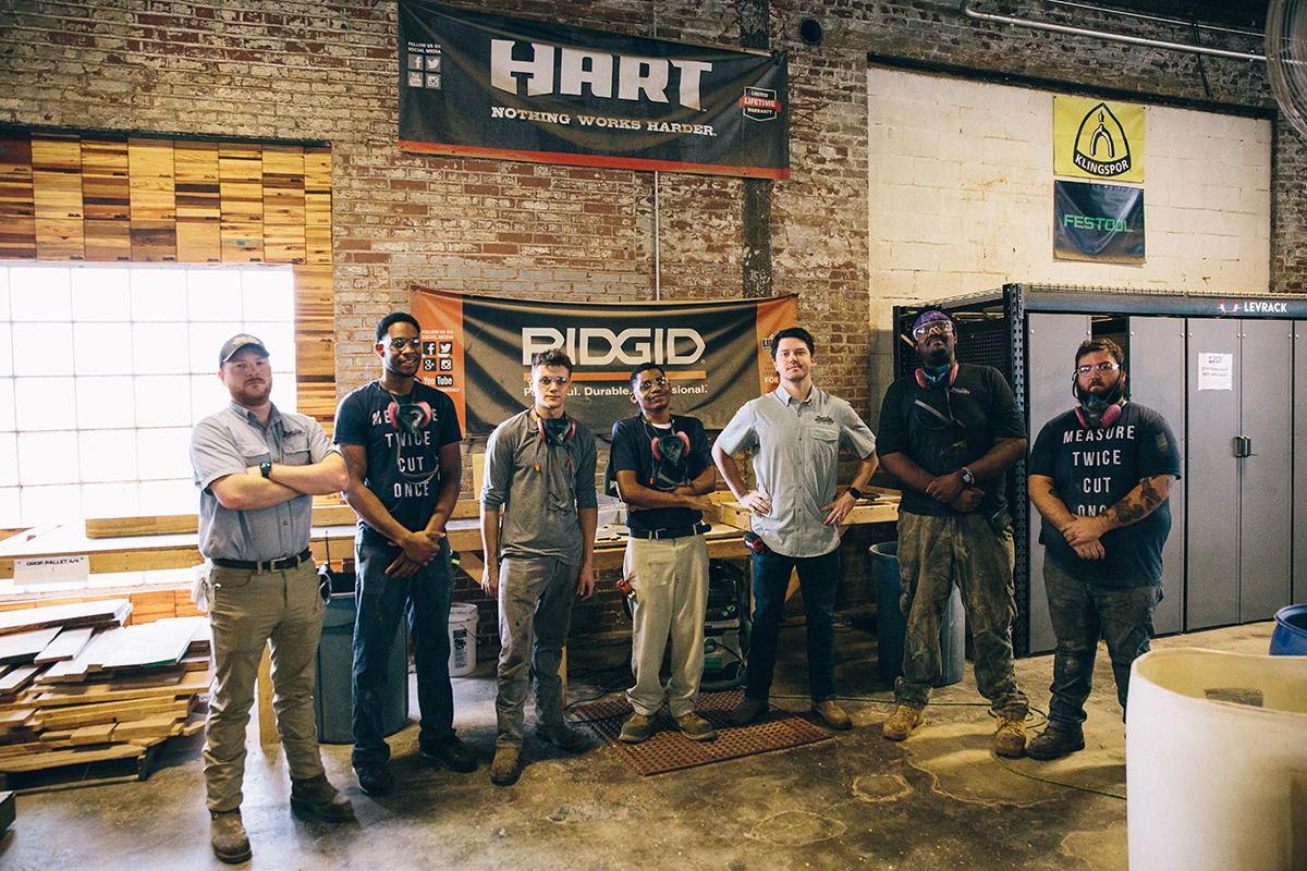 Group of Magic City Woodworks employees posing together for photo, in workshop.