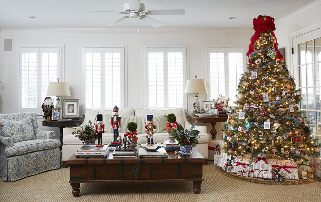 A large Christmas Tree in the corner of a traditionally Christmas styled living room.