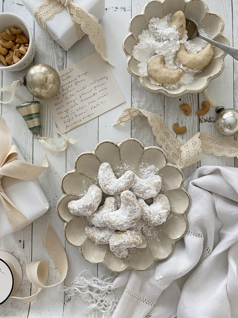 Southern Cashew Crescents on a plate covered in powdered sugar.