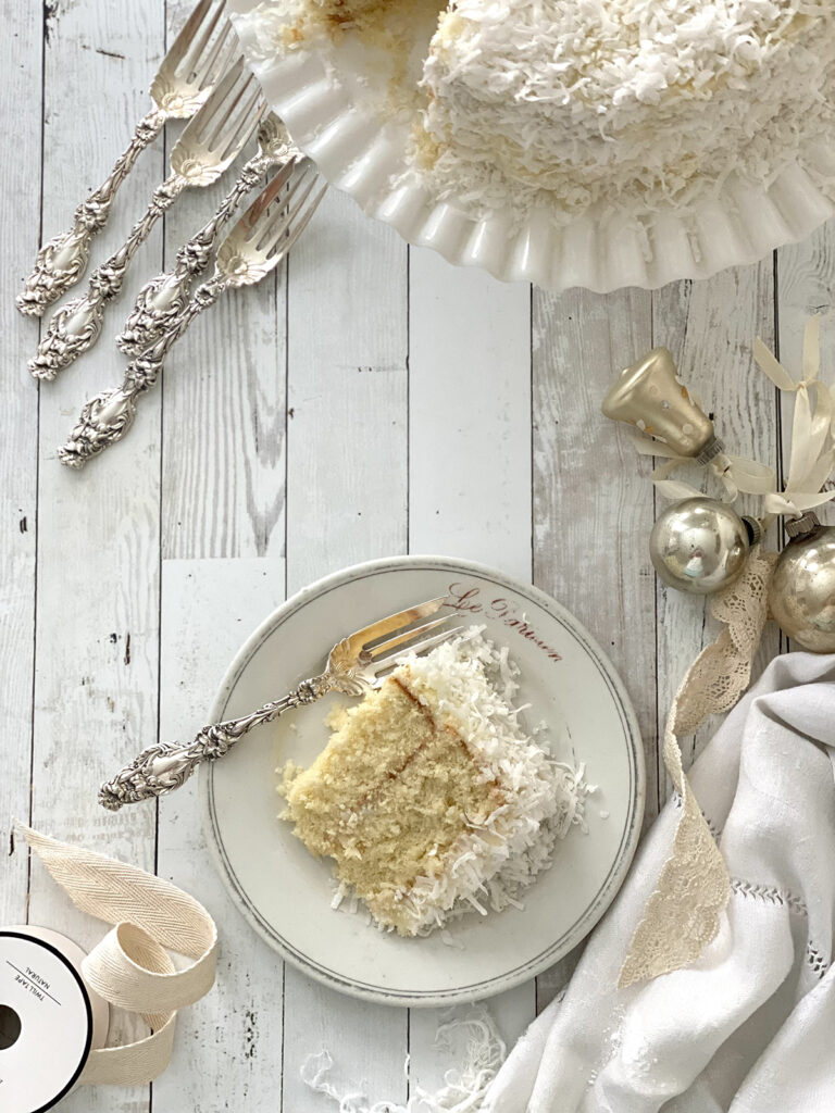 Slice of Coconut cake on a plate with fork.