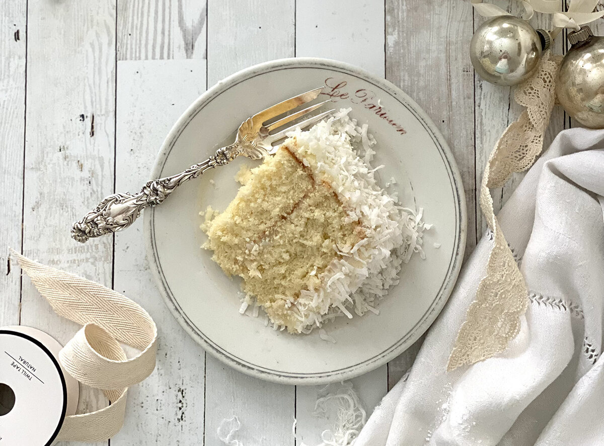 Slice of Coconut cake on a plate with fork.