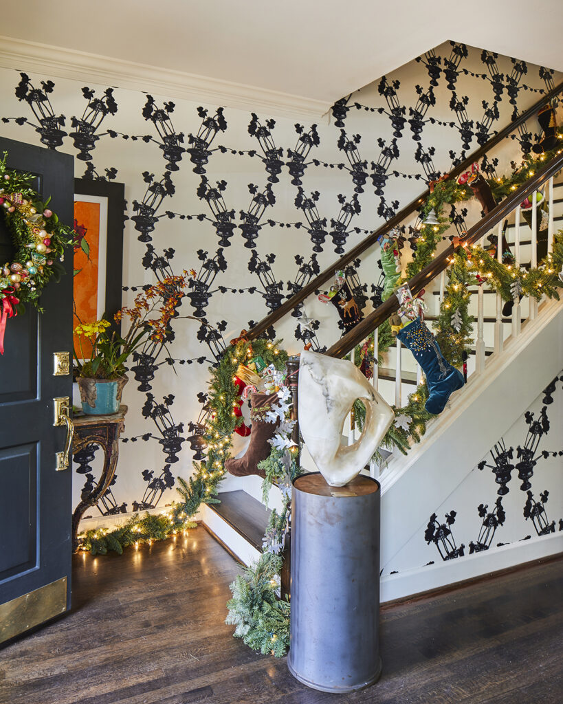 Staircase with garland on railing and stocking hung from railing.