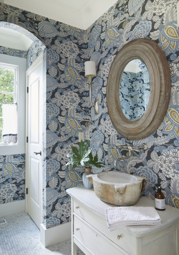 Half bath with bold blue floral wallpaper.