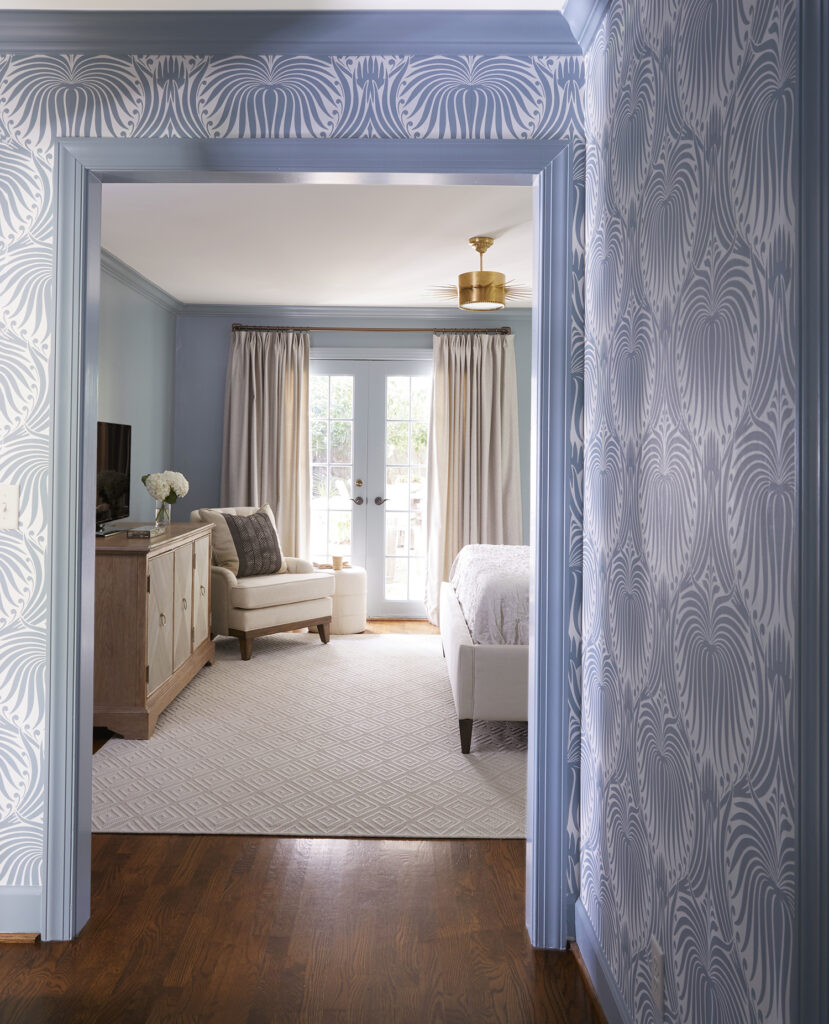blue and white pattered wallpaper draws your eye into the main bedroom from the hall.
