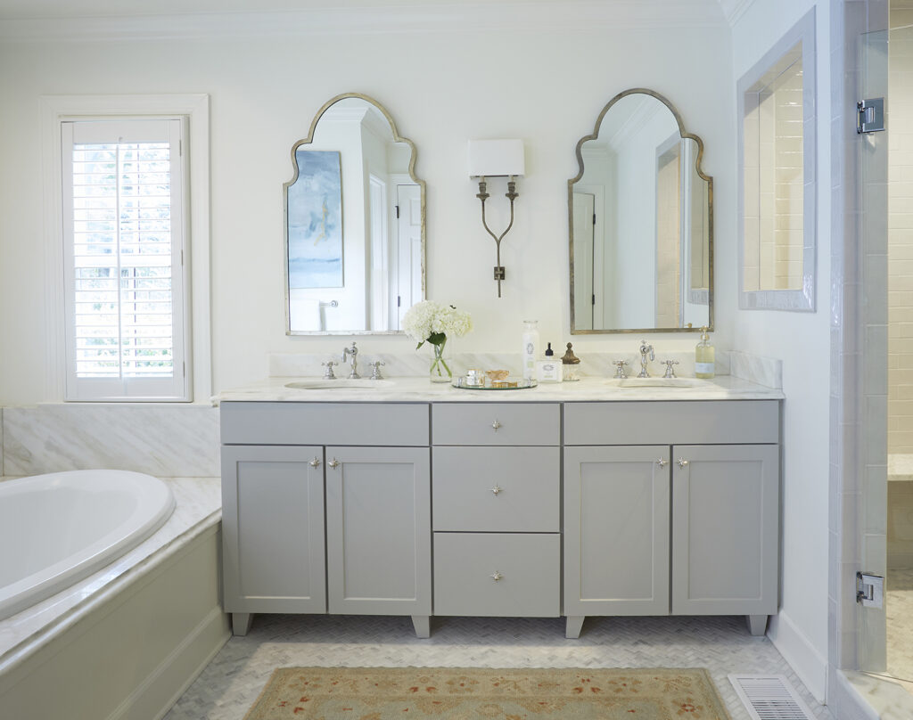Serene main bath with arched mirrors and detailed cabinet knobs.