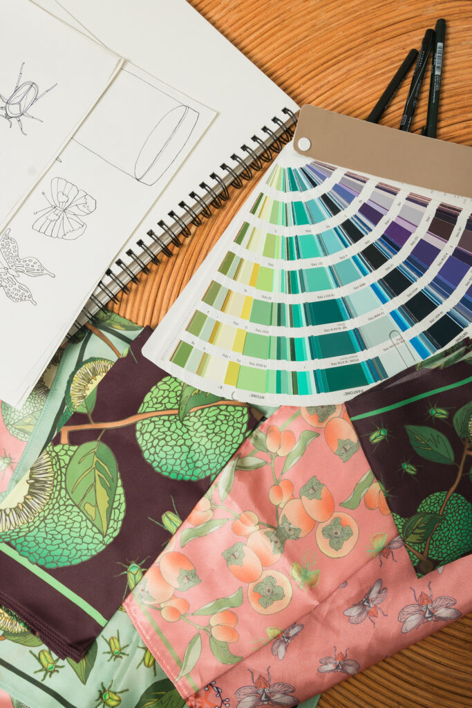 Fabric swatches, color deck, and hand drawn fabric designs on a work table.