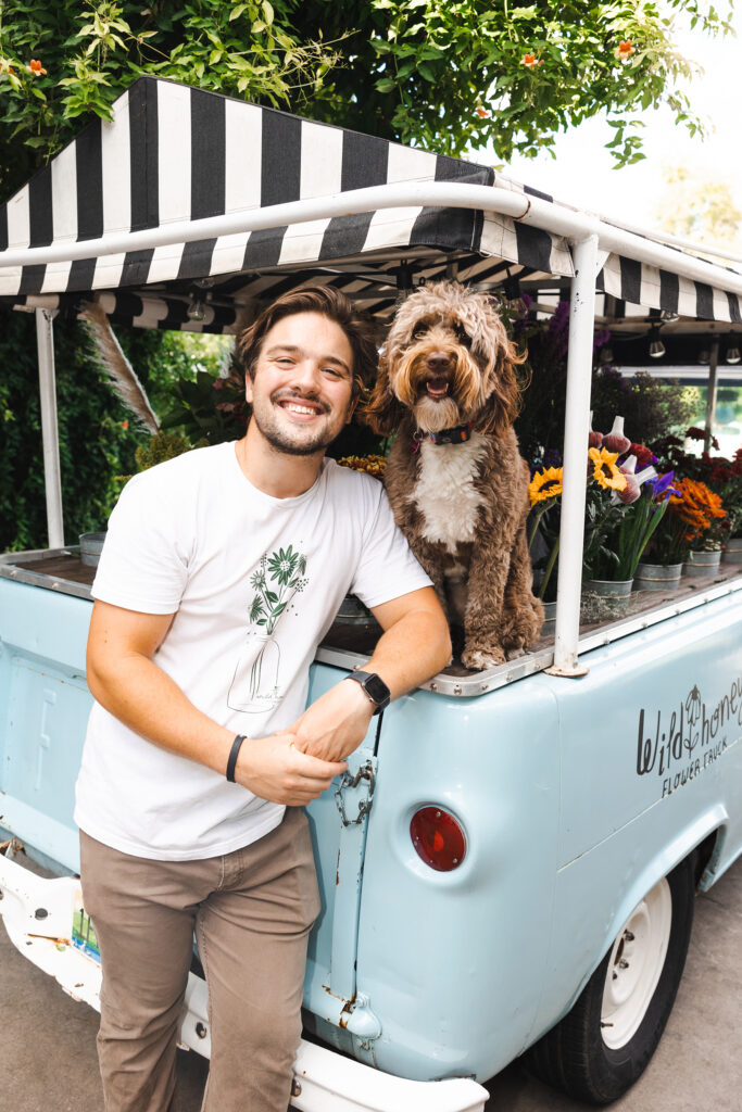 Drew and (dog) Zella posing with the Wild Honey Flower Truck.