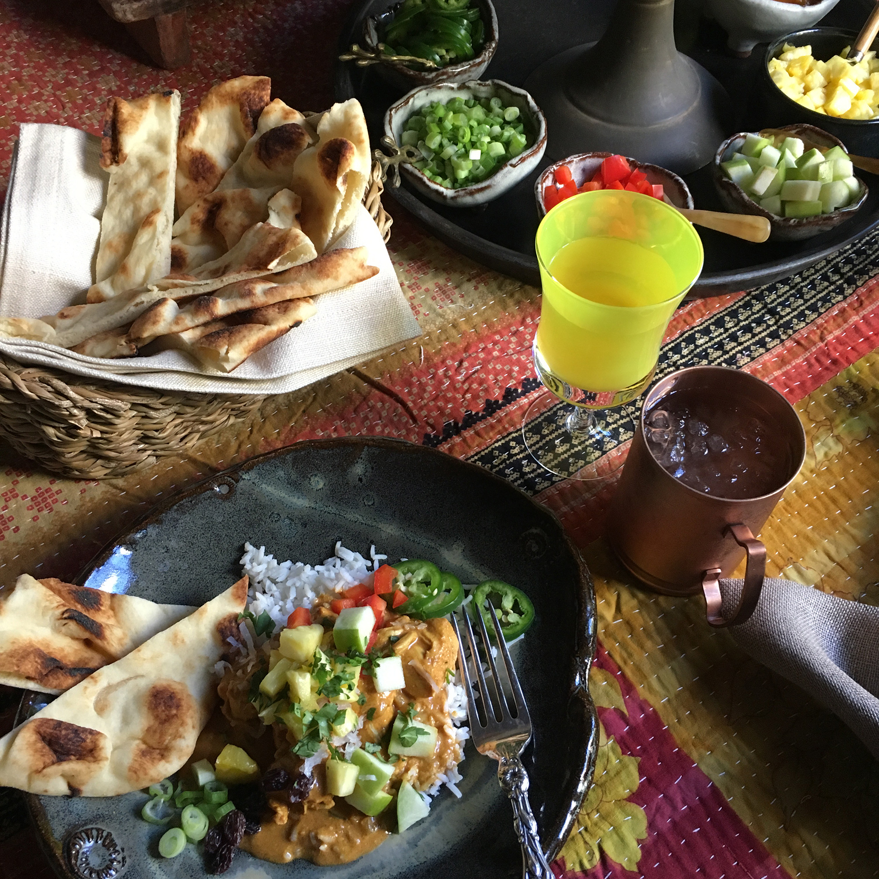 Chicken Curry, naan bread, and bowls of toppings