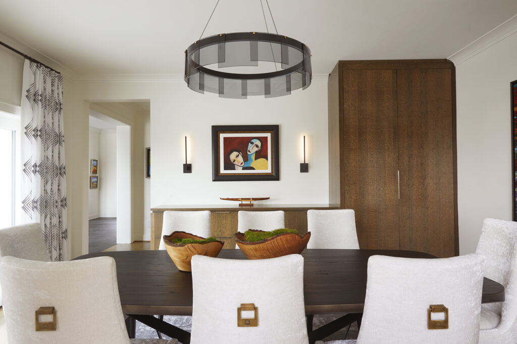 The dining room is filled with simple and elegant furniture pieces that keep the attention on the art in the room.