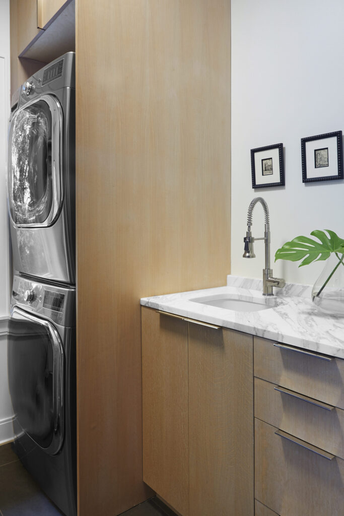 Laundry room with small art framed and hung above sink