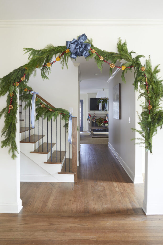 Garland adorned with a string of cranberries and dried orange slices decorated the arch to the living room and banister leading to the second floor. 