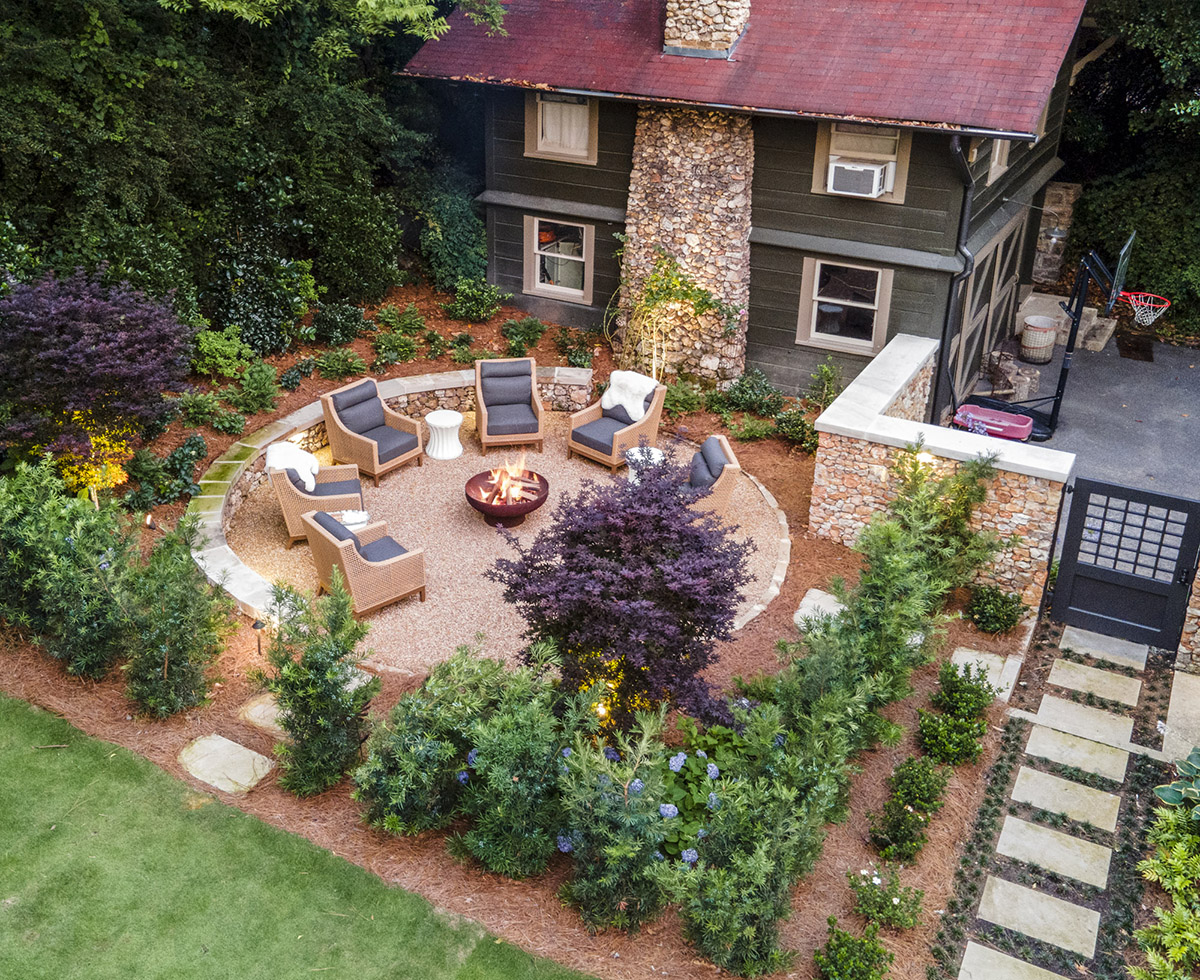 Landscaped backyard with a fire pit and custom stone walls