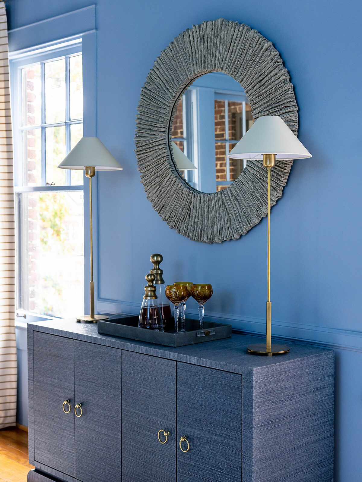 Grasscloth-covered buffet and round mirror